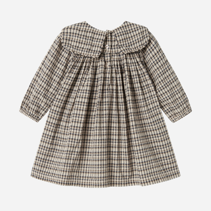 Sold at Bombon shop, designed by MarMar Copenhagen. Beige and navy check long-sleeve cotton dress with gathered yoke and front pockets.