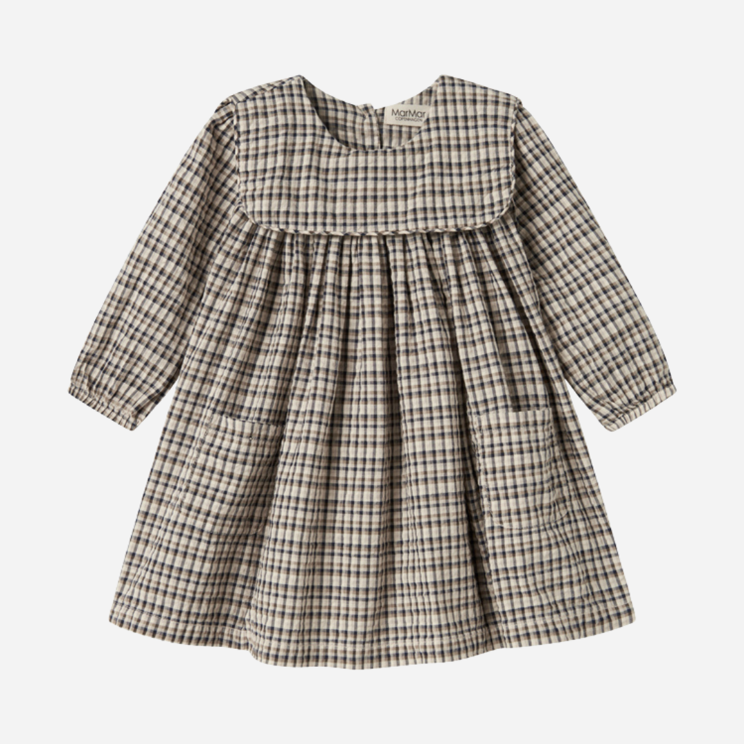Sold at Bombon shop, designed by MarMar Copenhagen. Beige and navy check long-sleeve cotton dress with gathered yoke and front pockets.