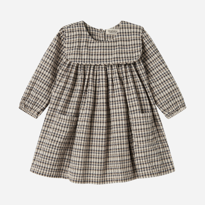 Sold at Bombon shop, designed by MarMar Copenhagen. Beige and navy check long-sleeve cotton dress with gathered yoke and front pockets.
