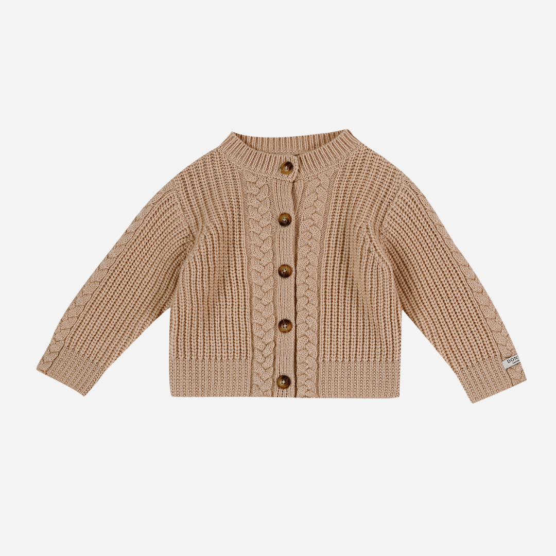 Sold at Bombon shop, designed by Donsje from Amsterdam, this baby and toddler girl cardigan in beige with a braid detail is the perfect pre-fall and transition piece. front view