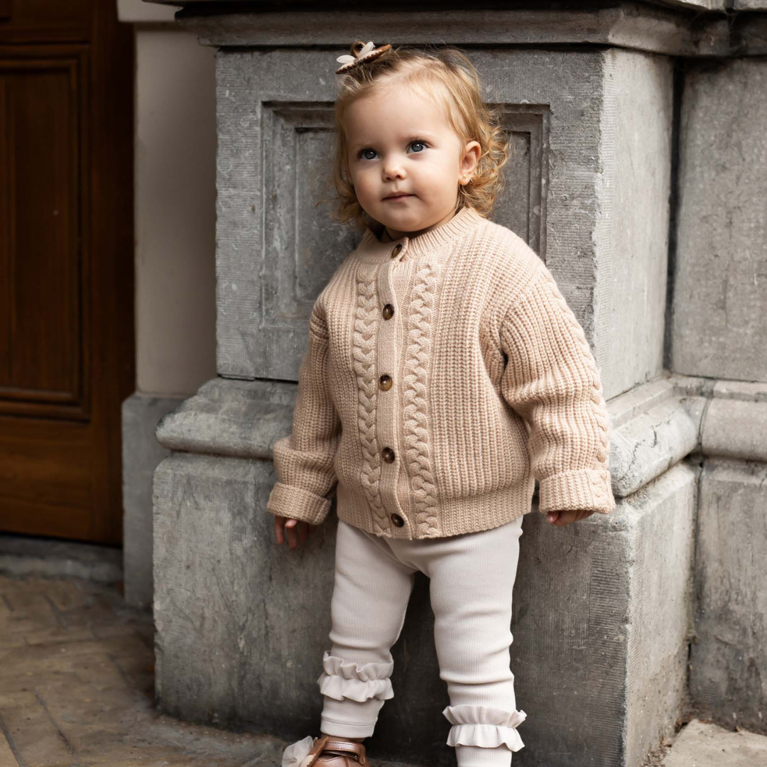 Sold at Bombon shop, designed by Donsje from Amsterdam, these leggings in a soft sand color and ruffle detail in the bottom leg for baby gris and toddler are the perfect piece for pre fall all the way through winter.  model view
