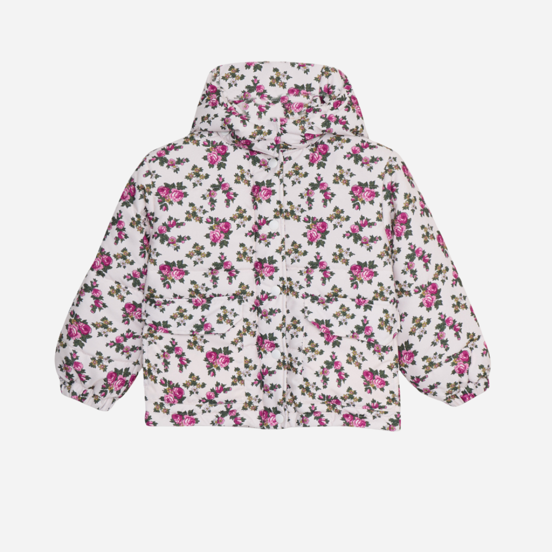 Sold at Bombon shop, this girls’ puffer jacket by The New Society features an all-over rose floral print on a cream base, complete with a hood, front pockets, and snap-button closure—combining warmth, function, and a touch of charm for cooler days. front