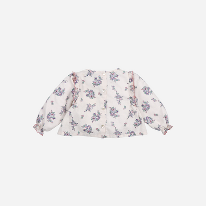 Sold at Bombon shop, this baby girl blouse by The New Society features a delicate floral print on a soft cream base, with ruffle detailing along the chest and shoulders, gathered cuffs, and a flared silhouette for a charming look. back