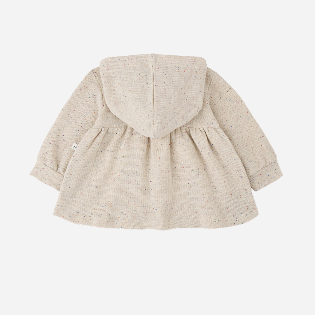 Sold at Bombon shop, designed by 1+ in the family — long-sleeve speckled beige baby dress with gathered waist and hood, shown flat on white background. back