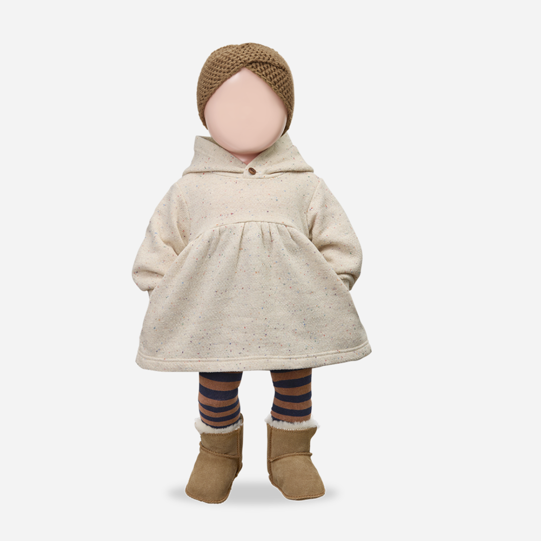 Sold at Bombon shop, designed by 1+ in the family — long-sleeve speckled beige baby dress with gathered waist and hood, shown flat on white background. mannequin