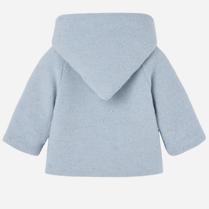 Sold at Bombon shop, designed by Paz Rodriguez, blue knit hooded baby coat with dot texture and button-up front from the Erizos collection.