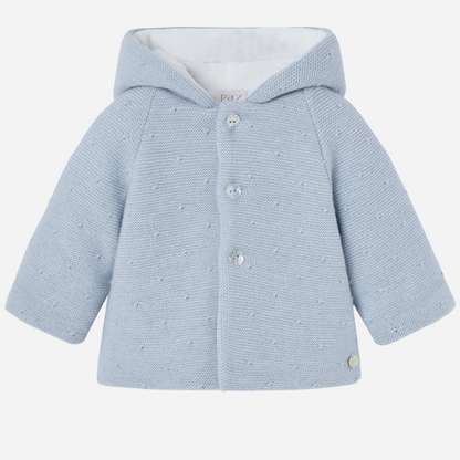 Sold at Bombon shop, designed by Paz Rodriguez, blue knit hooded baby coat with dot texture and button-up front from the Erizos collection.