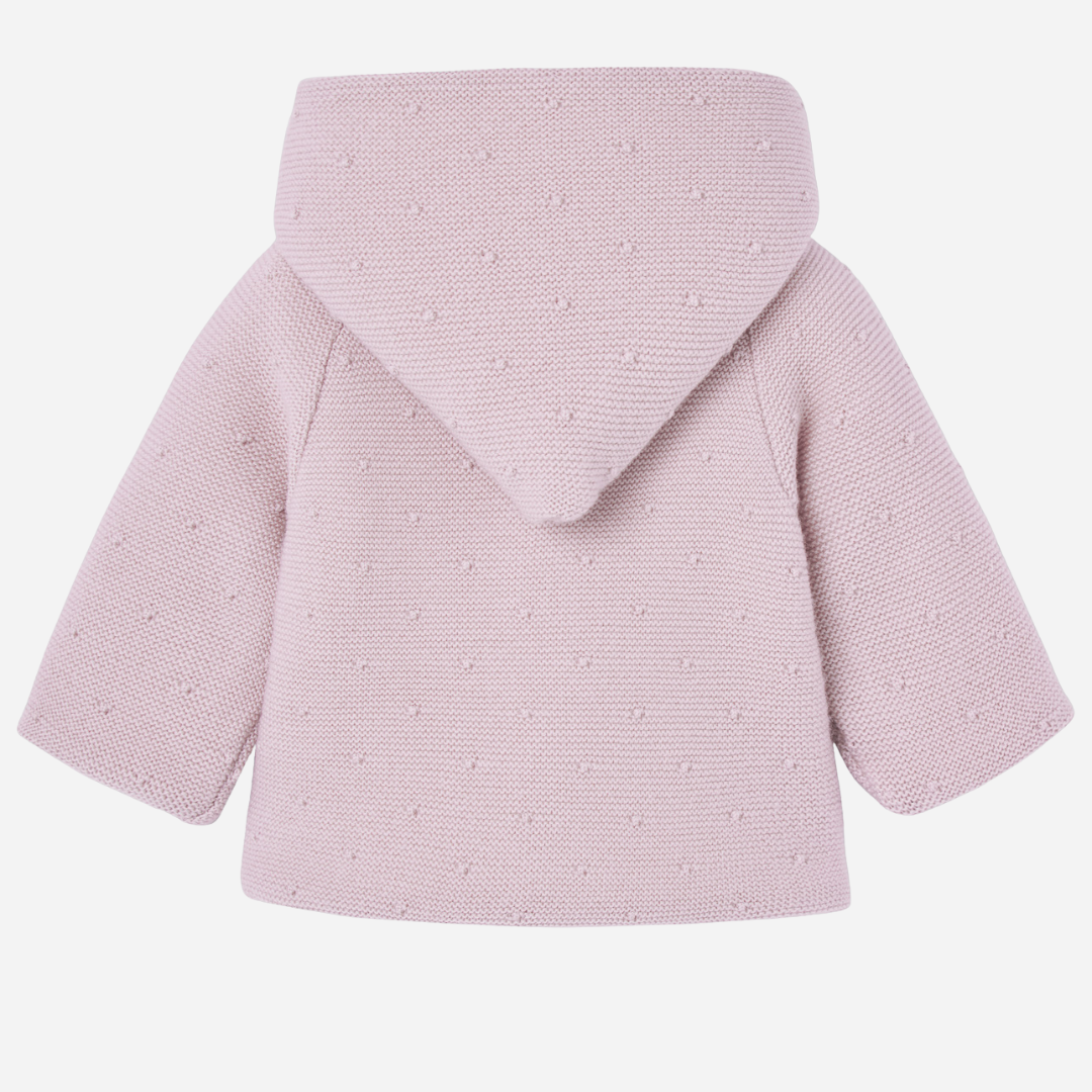 Sold at Bombon shop, designed by Paz Rodriguez, pink knit hooded baby coat with dot texture and button-up front from the Erizos collection.