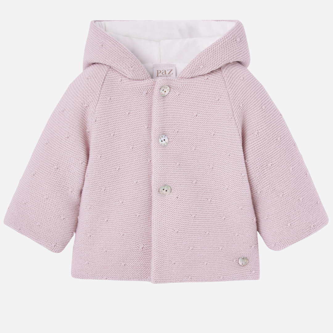 Sold at Bombon shop, designed by Paz Rodriguez, pink knit hooded baby coat with dot texture and button-up front from the Erizos collection.