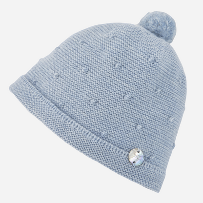Sold at Bombon shop, designed by Paz Rodriguez, light blue knit baby hat with pom-pom and delicate textured bobble details.