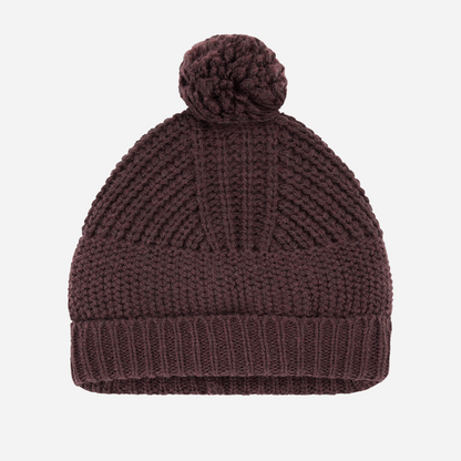 Sold at Bombon shop, designed by 1+ in the family — dark purple melanzana knit baby beanie with pom-pom and wide fold-over brim, displayed flat on a white background. front