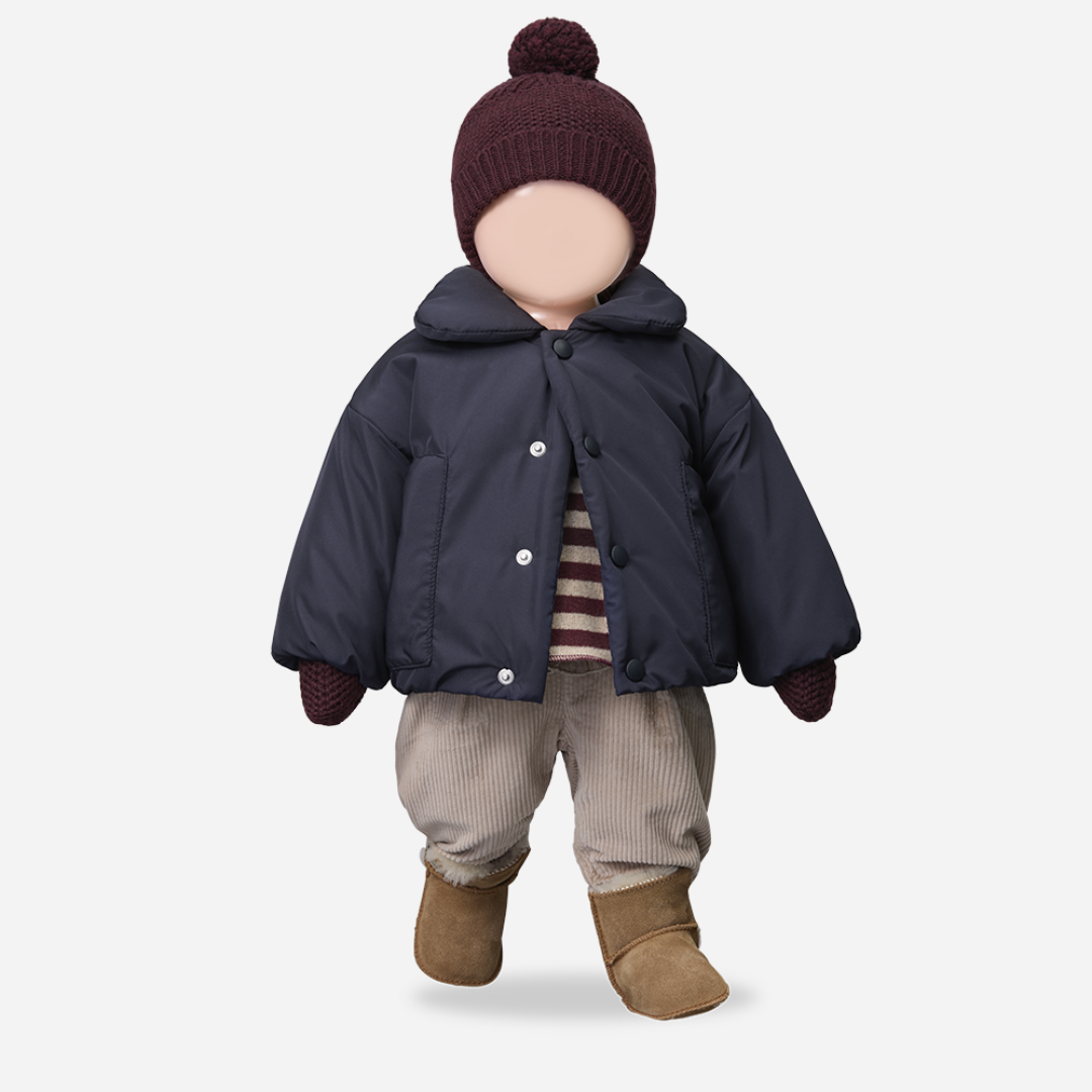 Sold at Bombon shop, designed by 1+ in the family — dark purple melanzana knit baby beanie with pom-pom and wide fold-over brim, displayed flat on a white background. mannequin