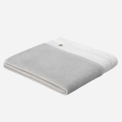 Sold at Bombon shop, designed by Paz Rodriguez. Folded grey velour baby blanket with white trim and decorative stitching.