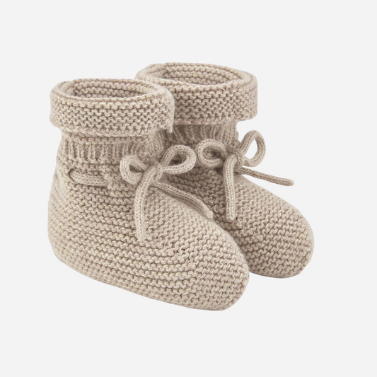 Sold at Bombon shop, designed by Paz Rodriguez. Beige knit baby booties with tie detail and rolled cuff.