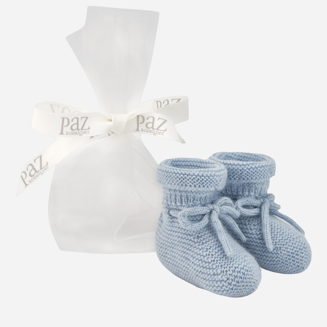 Sold at Bombon shop, designed by Paz Rodriguez. Light blue knit baby booties with tie detail and rolled cuff.