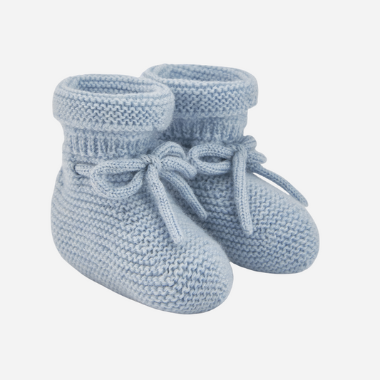 Sold at Bombon shop, designed by Paz Rodriguez. Light blue knit baby booties with tie detail and rolled cuff.