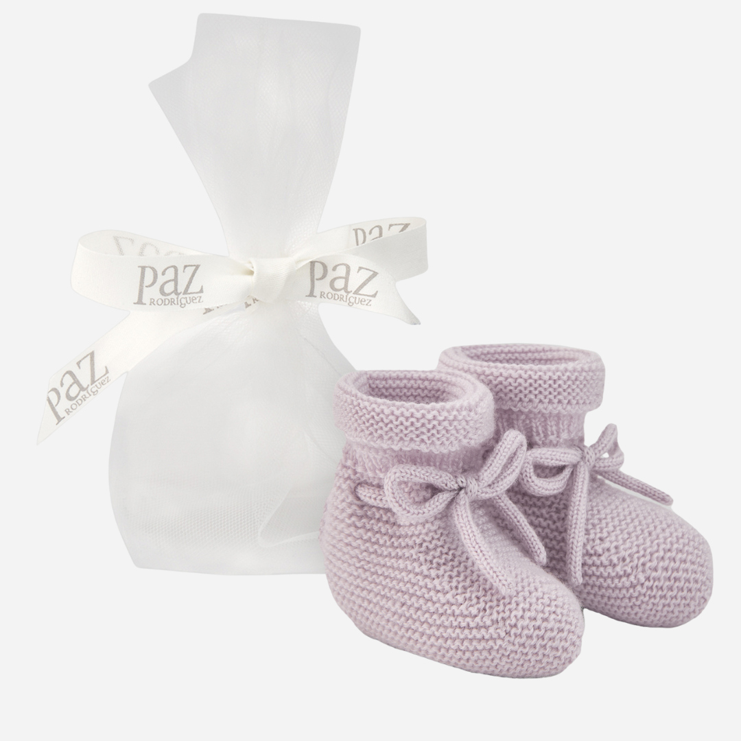 Sold at Bombon shop, designed by Paz Rodriguez. Pale pink knit baby booties with tie detail and rolled cuff