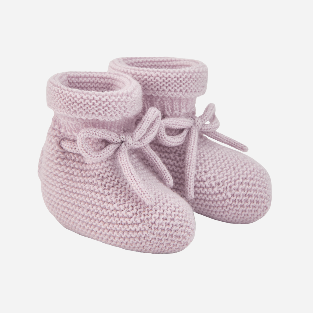 Sold at Bombon shop, designed by Paz Rodriguez. Pale pink knit baby booties with tie detail and rolled cuff