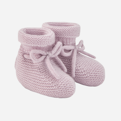 Sold at Bombon shop, designed by Paz Rodriguez. Pale pink knit baby booties with tie detail and rolled cuff