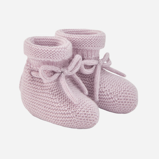 Sold at Bombon shop, designed by Paz Rodriguez. Pale pink knit baby booties with tie detail and rolled cuff