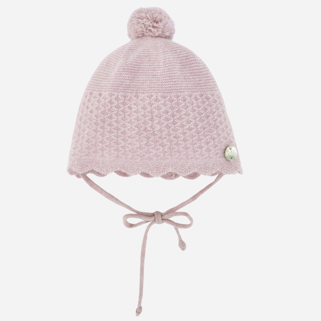 Sold at Bombon shop, designed by Paz Rodriguez, pale pink cashmere baby hat with scalloped trim and pompom.