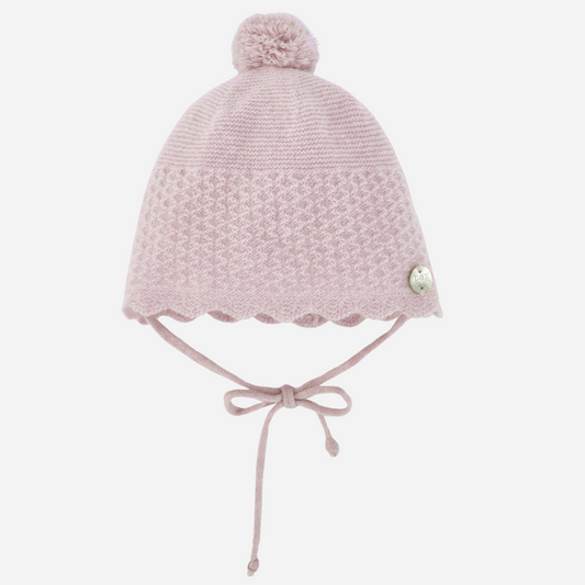 Sold at Bombon shop, designed by Paz Rodriguez, pale pink cashmere baby hat with scalloped trim and pompom.