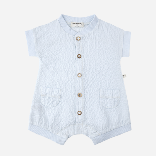 Sold at Bombon Shop, designed by 1+ in the family, misty blue baby overall with front button detail and textured cotton fabric.