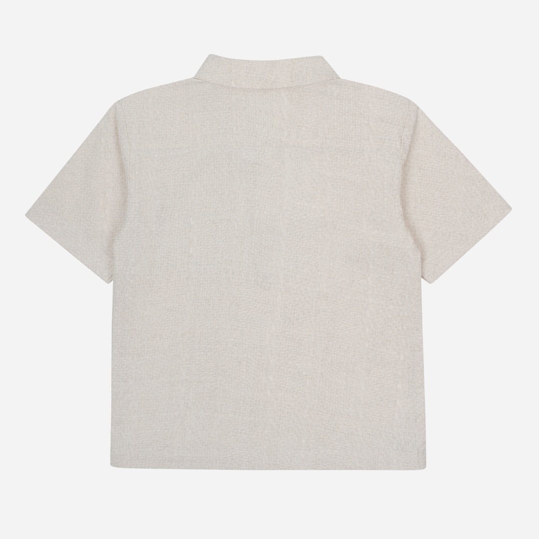 Sold at Bombon shop, designed by Donsje from Amsterdam, this baby and toddler short sleeve button down shirt in a warm white color for boys is the perfect pre-fall and transition piece. Back view