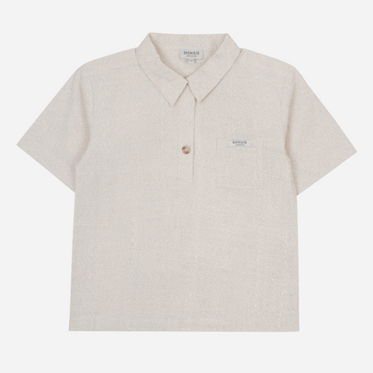 Sold at Bombon shop, designed by Donsje from Amsterdam, this baby and toddler short sleeve button down shirt in a warm white color for boys is the perfect pre-fall and transition piece. front view