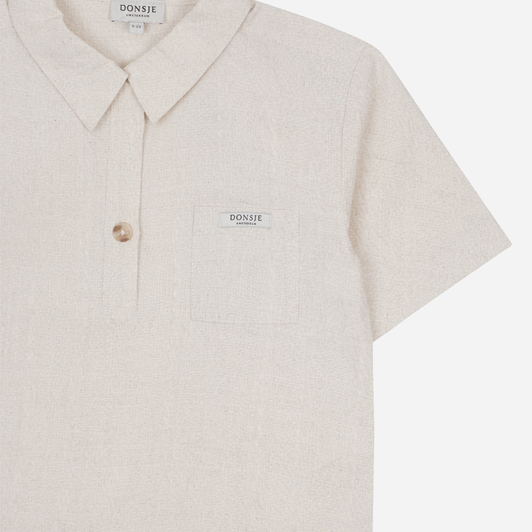 Sold at Bombon shop, designed by Donsje from Amsterdam, this baby and toddler short sleeve button down shirt in a warm white color for boys is the perfect pre-fall and transition piece. top view
