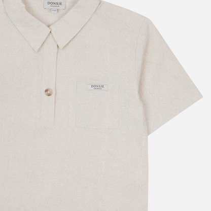 Sold at Bombon shop, designed by Donsje from Amsterdam, this baby and toddler short sleeve button down shirt in a warm white color for boys is the perfect pre-fall and transition piece. top view