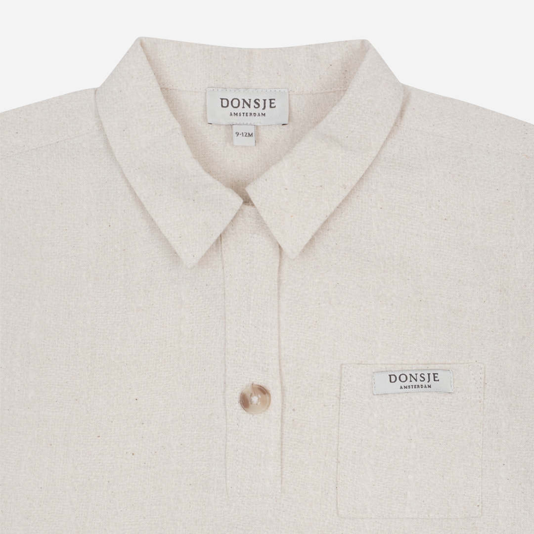 Sold at Bombon shop, designed by Donsje from Amsterdam, this baby and toddler short sleeve button down shirt in a warm white color for boys is the perfect pre-fall and transition piece. top view