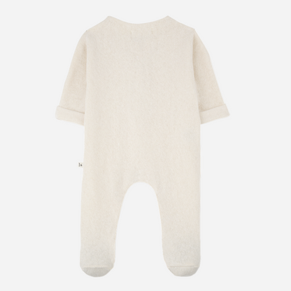 Sold at Bombon shop, designed by 1+ in the family — ecru footed baby jumpsuit with button placket and long sleeves. front
