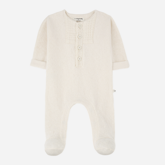 Sold at Bombon shop, designed by 1+ in the family — ecru footed baby jumpsuit with button placket and long sleeves. front