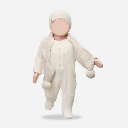 Sold at Bombon shop, designed by 1+ in the family — ecru footed baby jumpsuit with button placket and long sleeves. mannequin