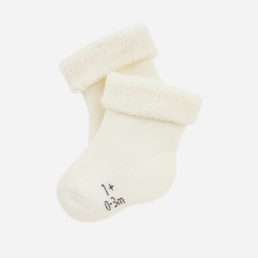 Sold at Bombon shop, designed by 1+ in the family — pair of ivory baby socks with plush folded cuffs and embroidered size marking. front