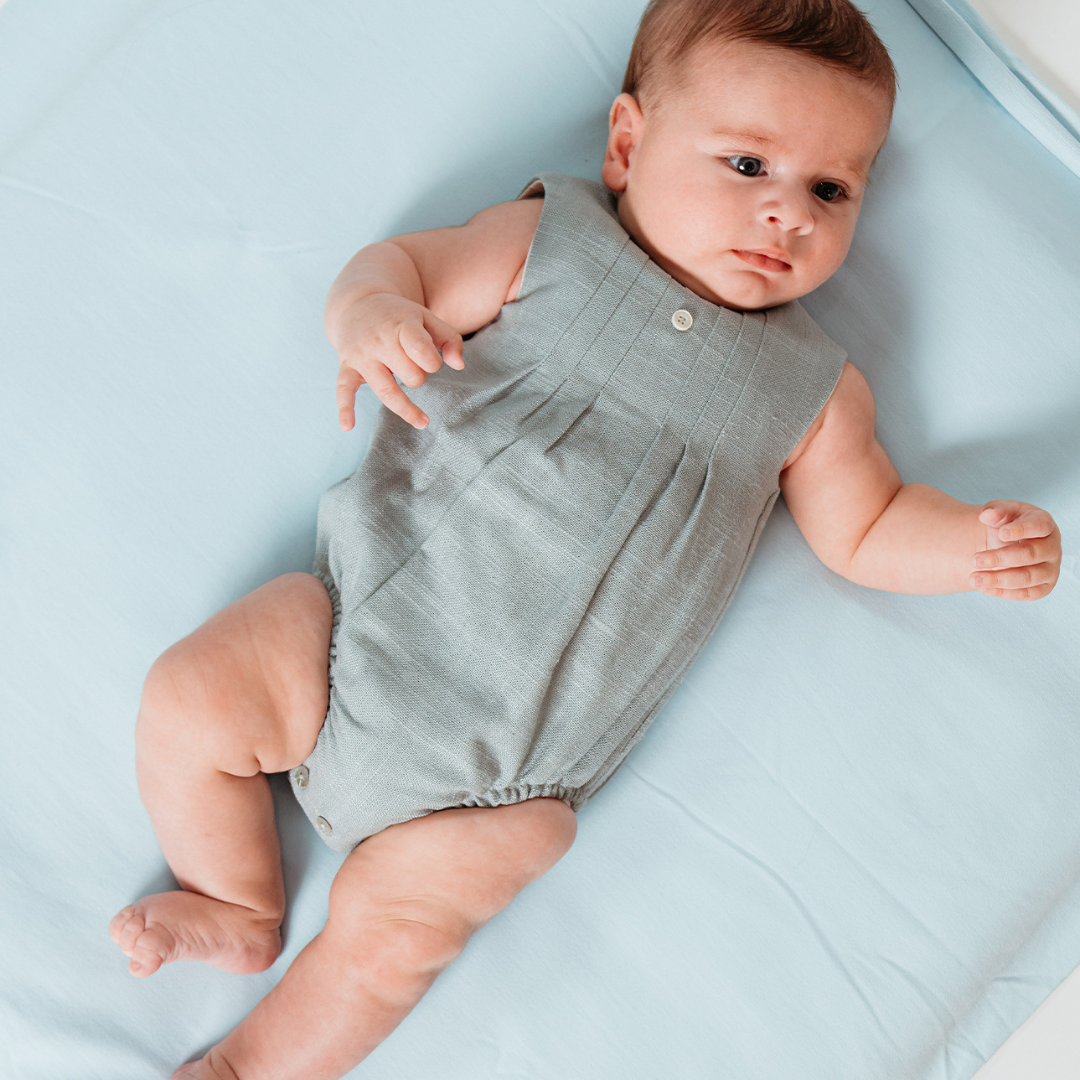 Sold at Bombon shop, designed by Fina Ejerique brand, green linen pleated baby romper perfect for spring and summer. Model view