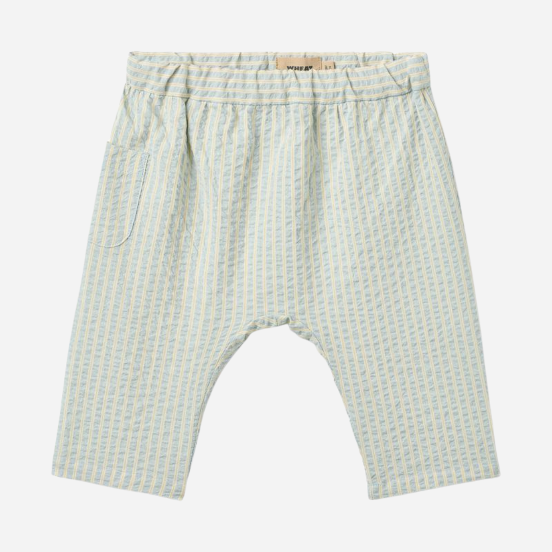 Sold at Bombon Shop, designed by Wheat, summer sky stripe organic cotton baby trousers with elastic waistband and soft blue vertical stripes.