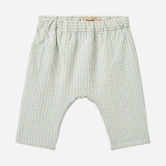 Sold at Bombon Shop, designed by Wheat, summer sky stripe organic cotton baby trousers with elastic waistband and soft blue vertical stripes.