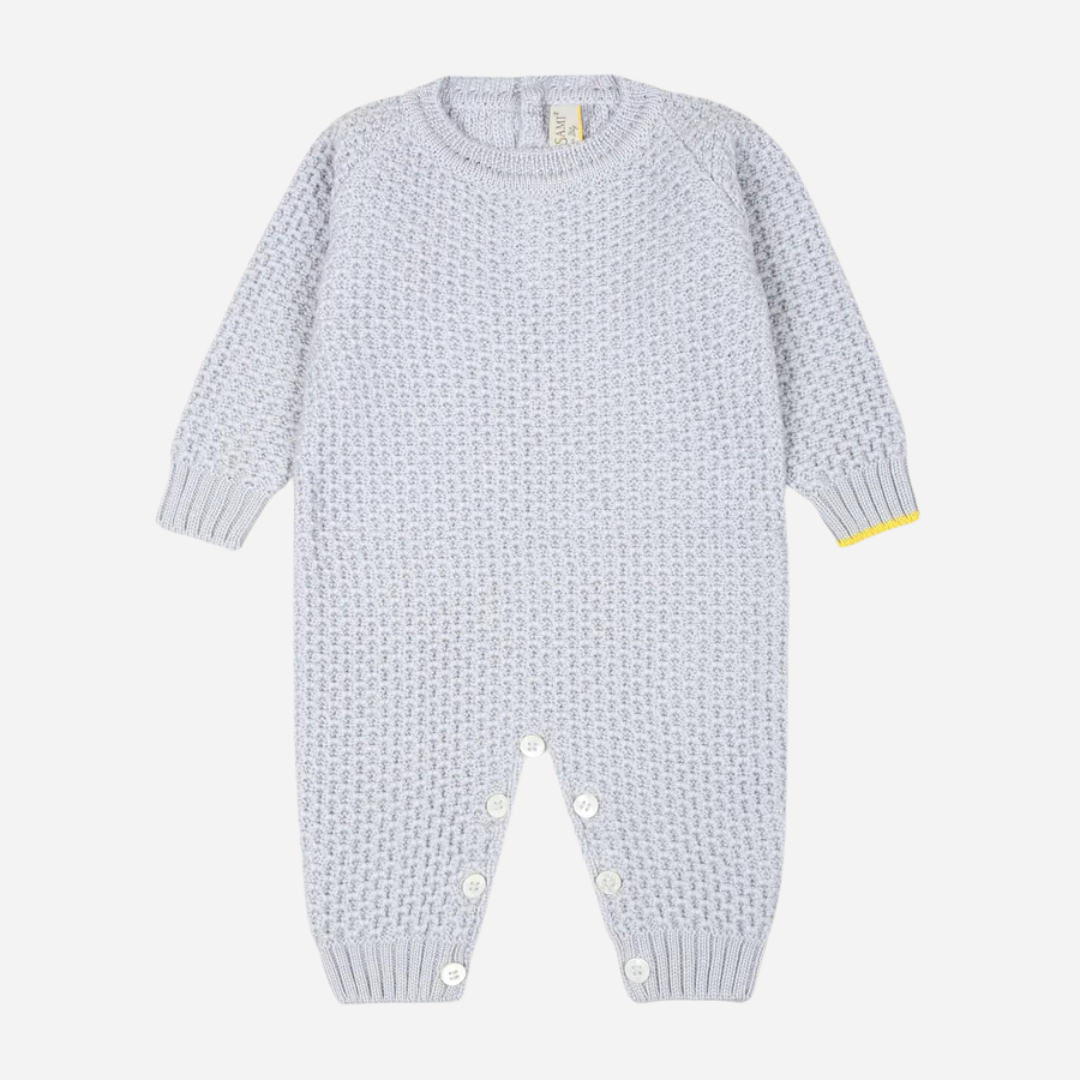 Sold at Bombon and designed by Gensami, a blue cotton knit baby jumpsuit with a yellow trim accent at the cuff.