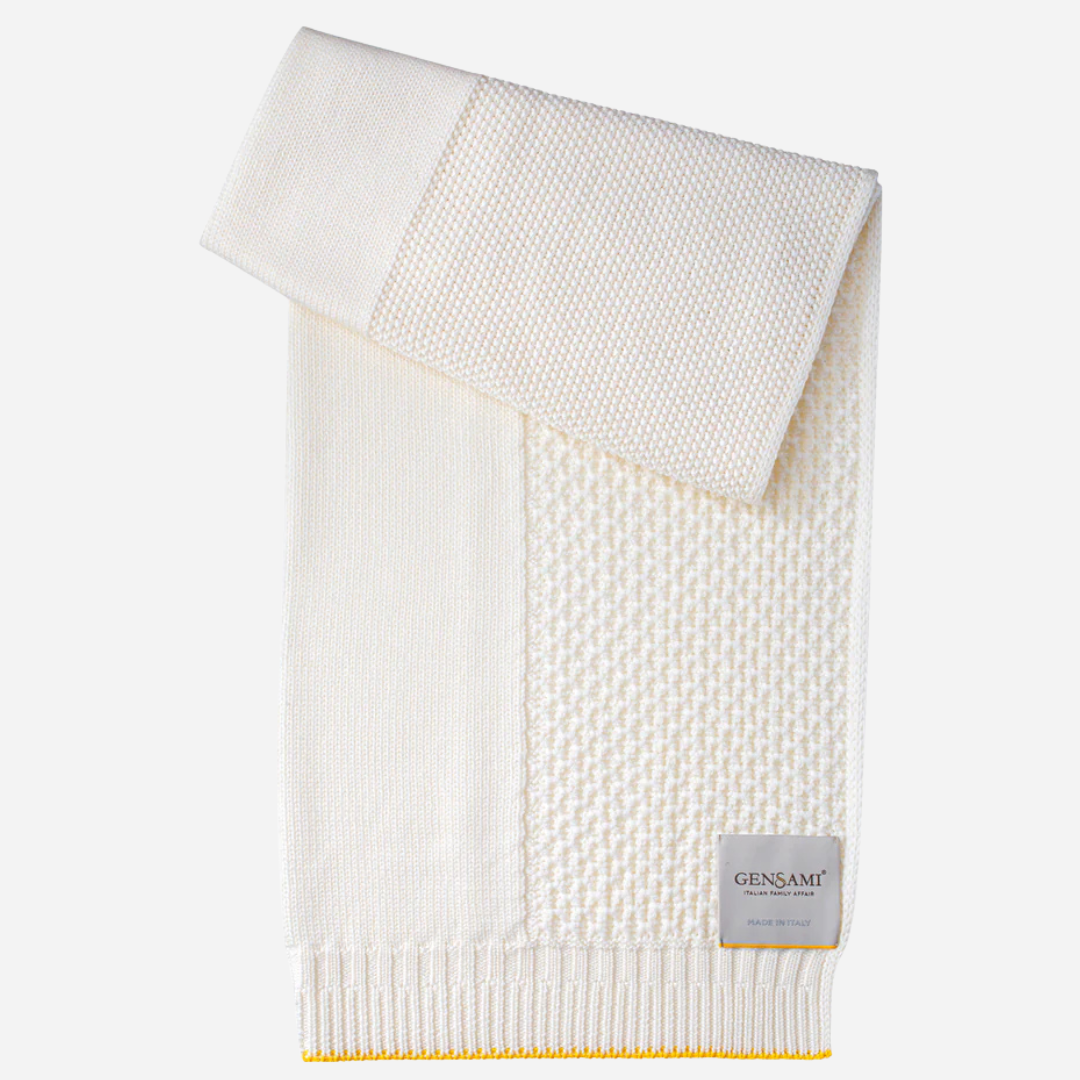 Sold at Bombon and designed by Gensami, an ivory knit baby blanket with a yellow trim
