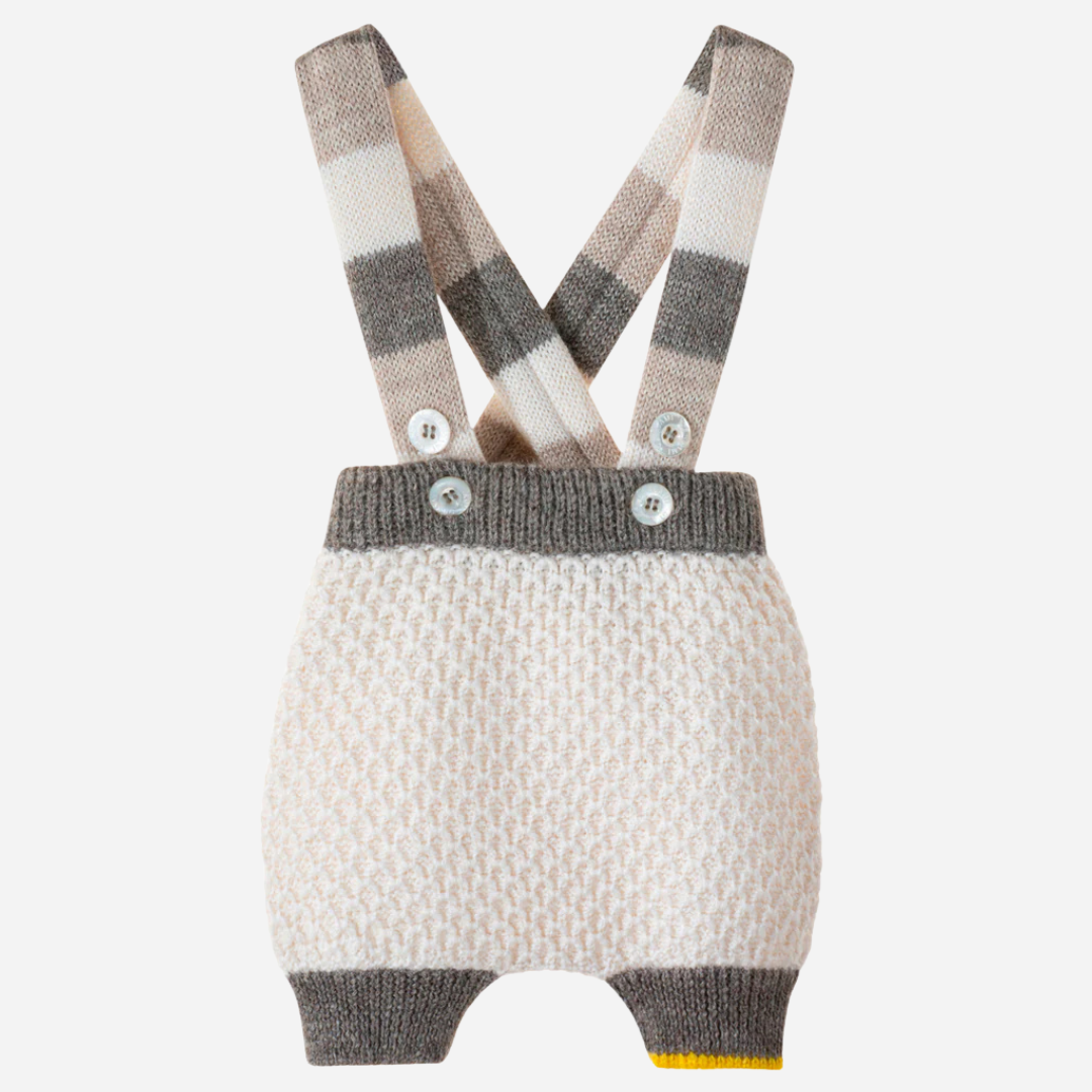 Sold at Bombon and designed by Gensami, an ivory knit baby bloomer with a textured pattern, striped suspenders in neutral beige and grey tones, and a yellow trim detail at the leg.