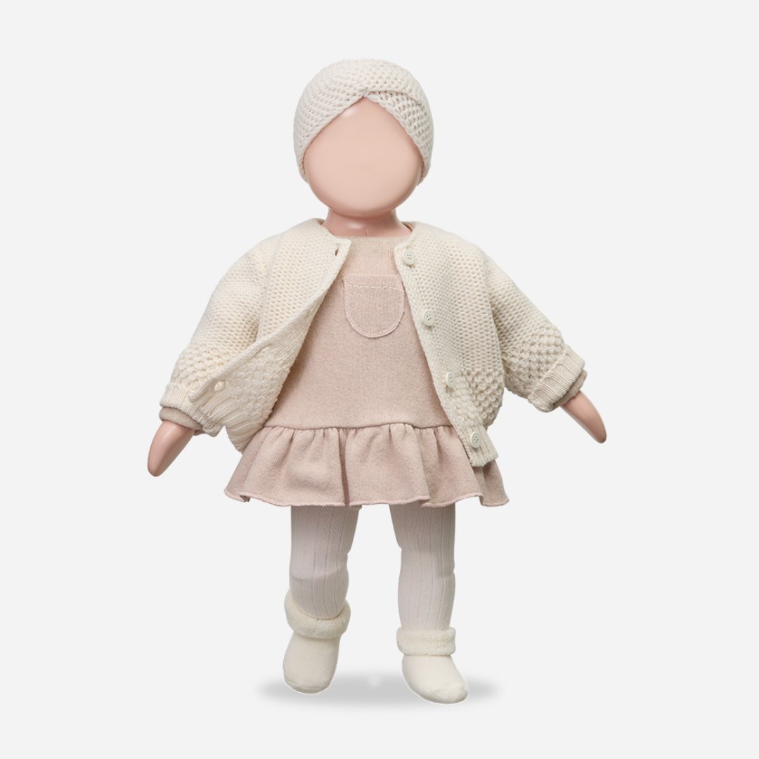 Baby doll wearing a cream outfit with a white background