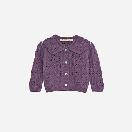 Sold at Bombon shop, this baby girl cardigan by The New Society features a delicate pointelle knit in soft lilac, a scalloped Peter Pan collar, and front button closure—perfect for adding a charming touch to any outfit. front