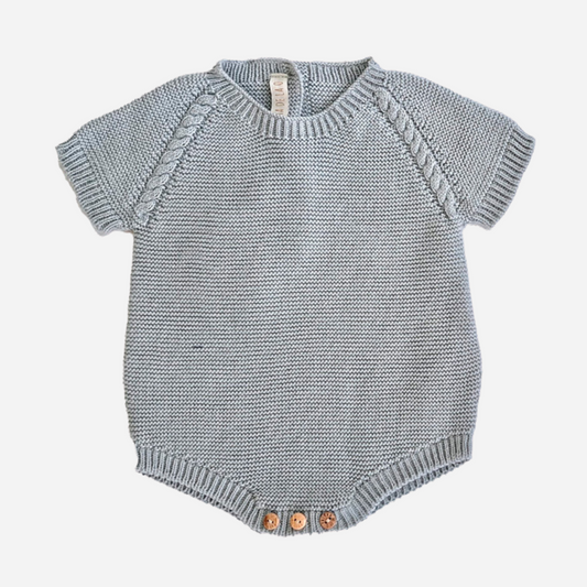 Sold at Bombon shop, designed by Paloma de la O brand, this knitted romper in light blue for baby boys is designed to keep them cozy in any occasion