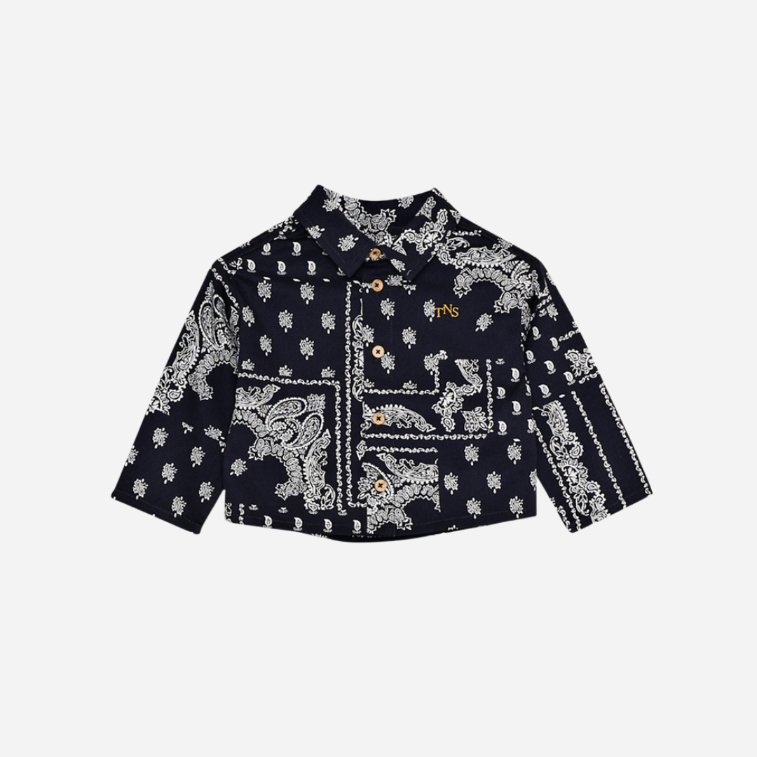 Sold at Bombon shop, this baby and toddler boy shirt by The New Society features a bold navy and white bandana-style print, long sleeves, front buttons, and a chest pocket embroidered with “TNS” for a stylish, laid-back look. baby version, front