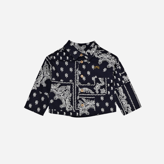 Sold at Bombon shop, this baby and toddler boy shirt by The New Society features a bold navy and white bandana-style print, long sleeves, front buttons, and a chest pocket embroidered with “TNS” for a stylish, laid-back look. baby version, front