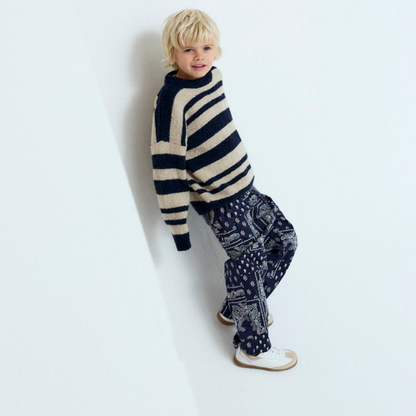 Sold at Bombon shop, these baby and toddler boy pants by The New Society feature a matching navy and white bandana print with an elastic waistband for an easy, comfortable fit—perfect for pairing with the coordinated shirt or mixing with basics. model view