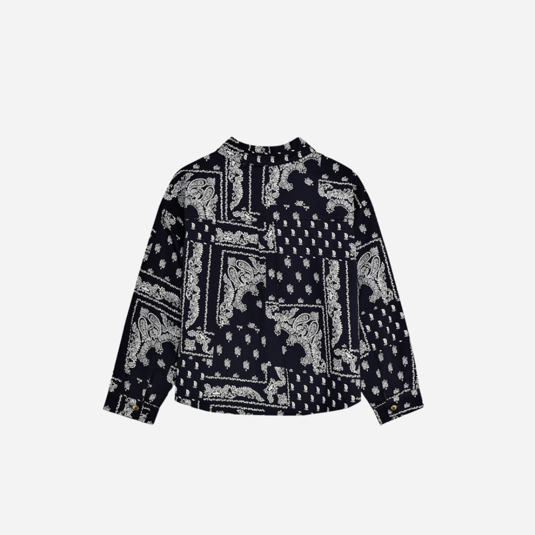Sold at Bombon shop, this baby and toddler boy shirt by The New Society features a bold navy and white bandana-style print, long sleeves, front buttons, and a chest pocket embroidered with “TNS” for a stylish, laid-back look. toddler version, back