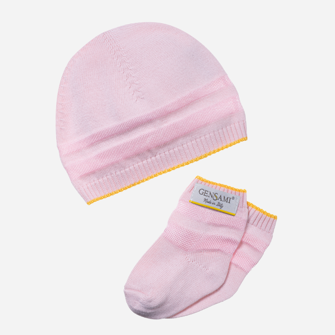 Sold at Bombon and designed by Gensami, a pink newborn layette set featuring a knit jumpsuit, hat, socks, and matching blanket with yellow stripe accents